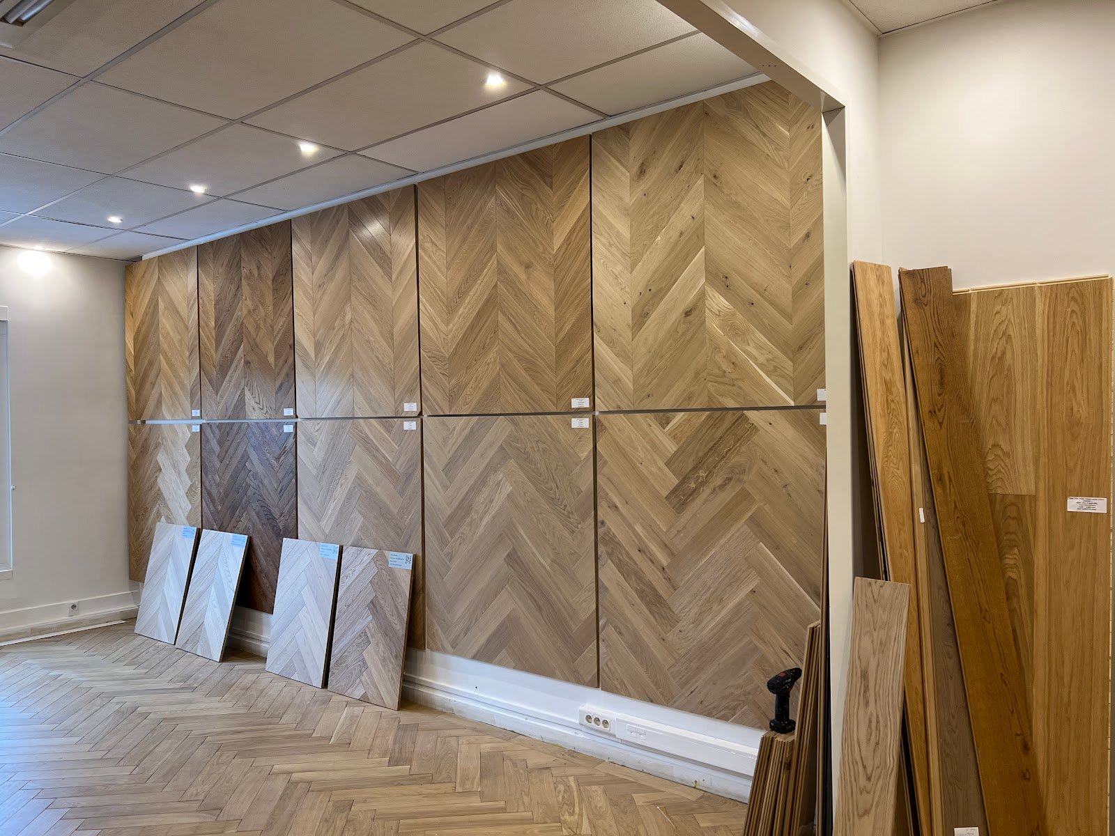 Mur d’exposition des motifs chevron et bâton rompu, camaïeu de teintes chêne